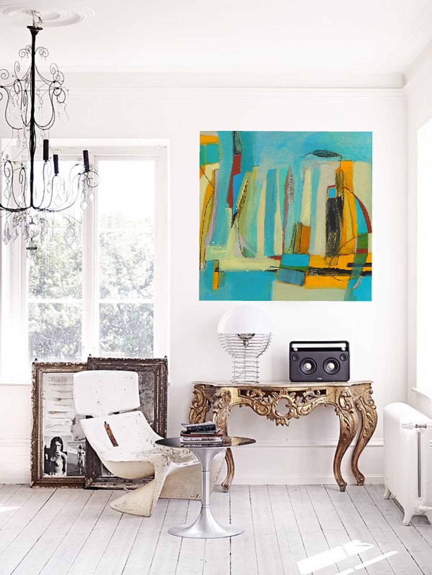 Aqua blue pale yellow and gold abstract oil painting on canvas created by artist danielle nelisse installed on modern wall above ornate gold desk and white modern chair with black wrought iron chandelier hanging from ceiling next to large windows