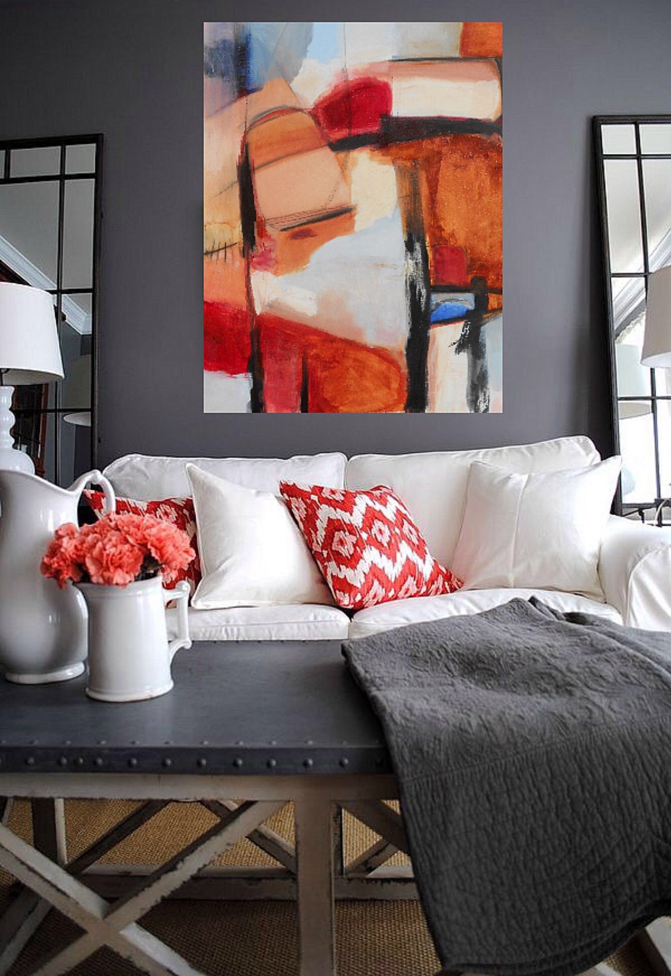 pale blue and rust colored abstract painting on canvas on gray wall in living room