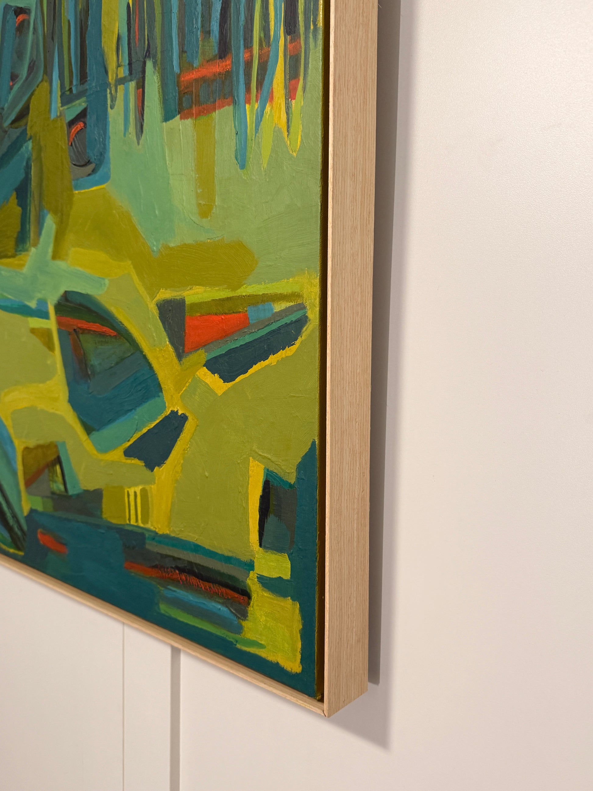 Abstract nature oil painting with green and blue tones on a white wall.